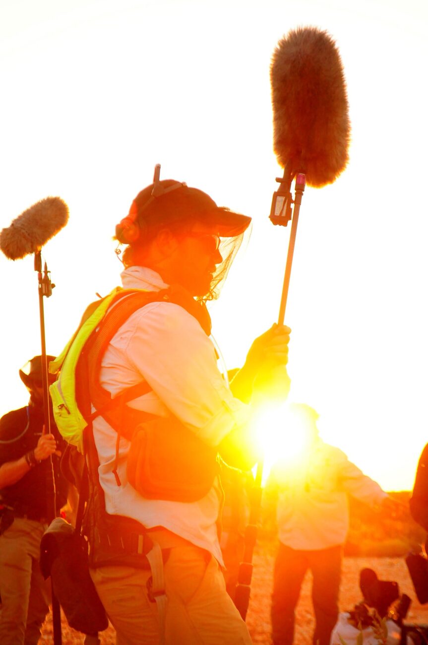 Richard Hubbard booming on location, silhouetted against the setting sun